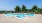 a swimming pool with trees in the background