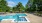 a pool with chairs and umbrellas by it